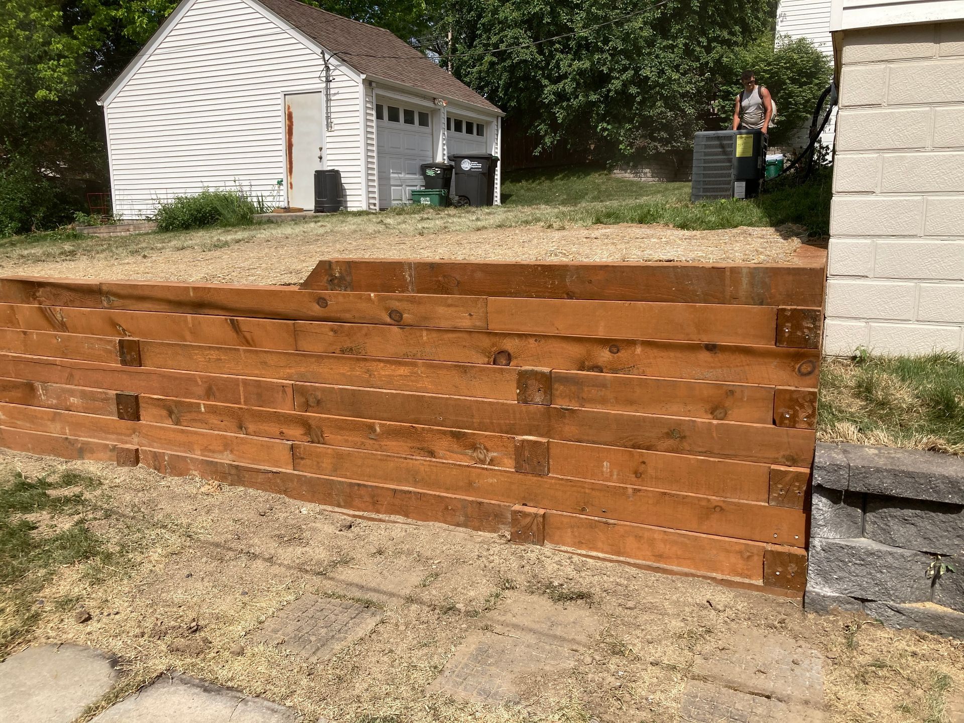 a wooden retaining wall is being built in front of a house