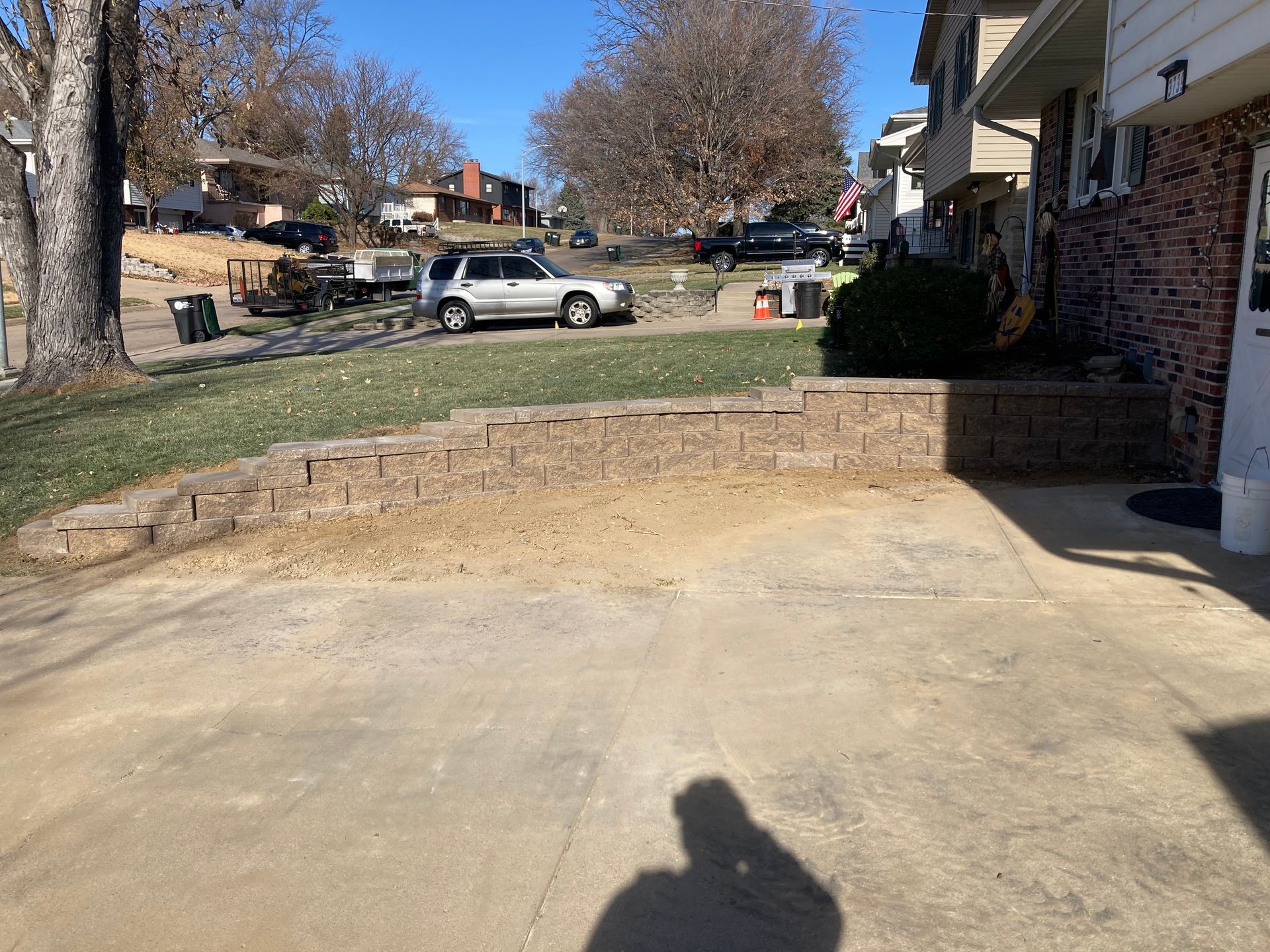 a car is parked in a driveway next to a brick wall
