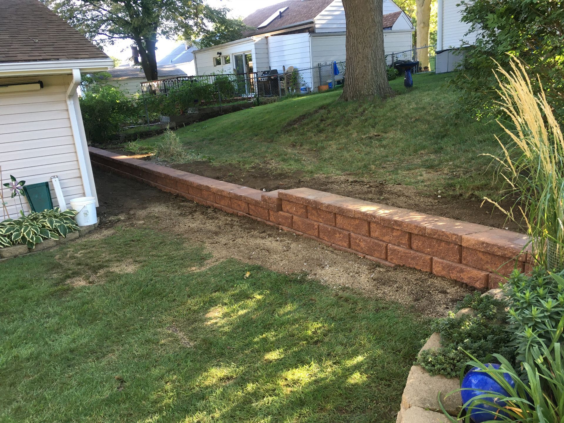a brick wall is being built in the backyard of a house