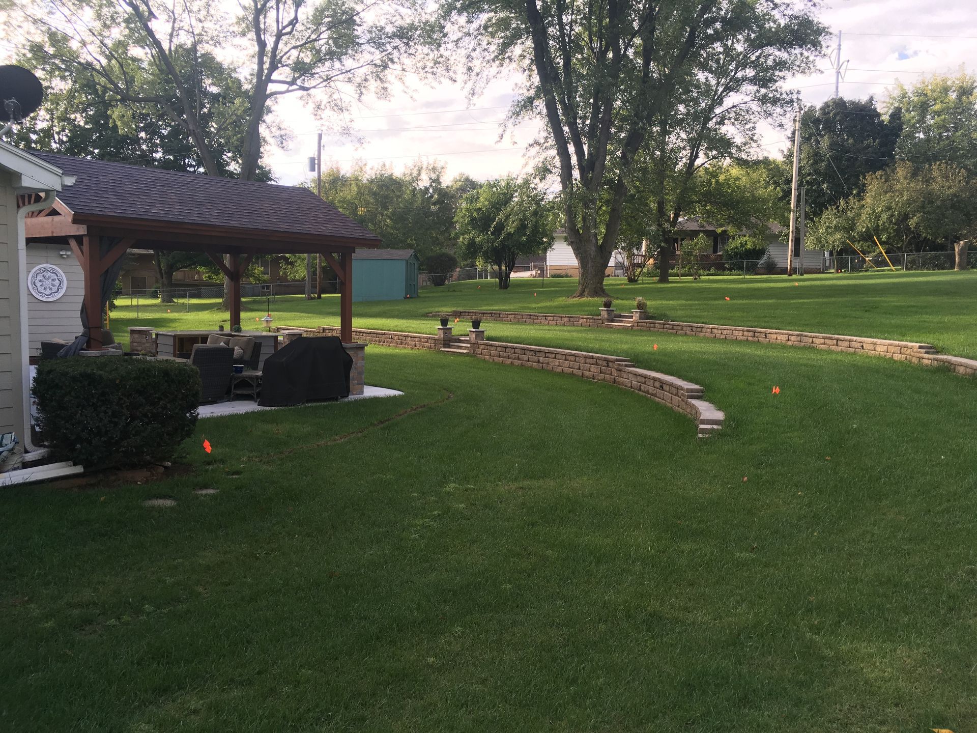 a large lush green lawn with a shed in the background