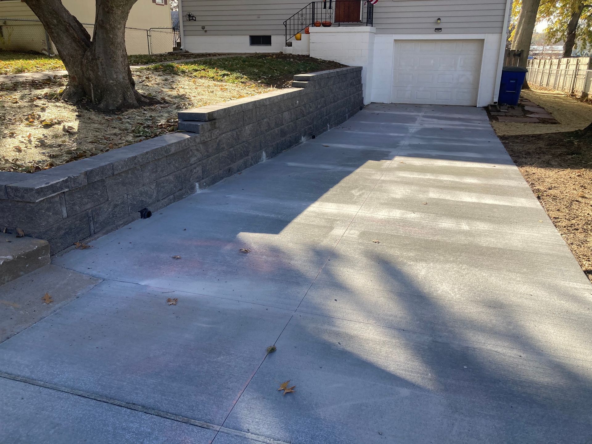 a concrete driveway leading to a garage next to a house