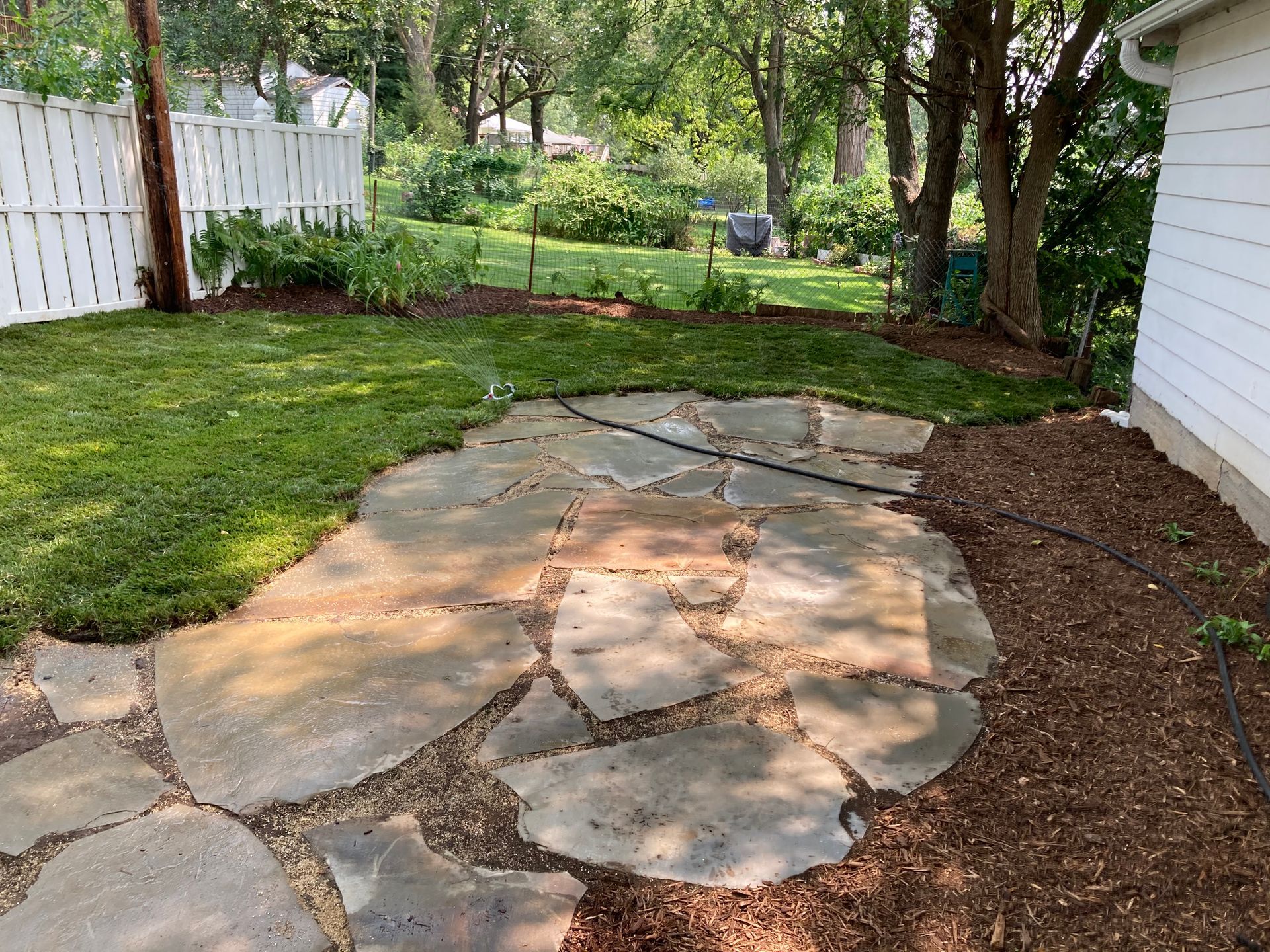 there is a stone patio in the backyard of a house
