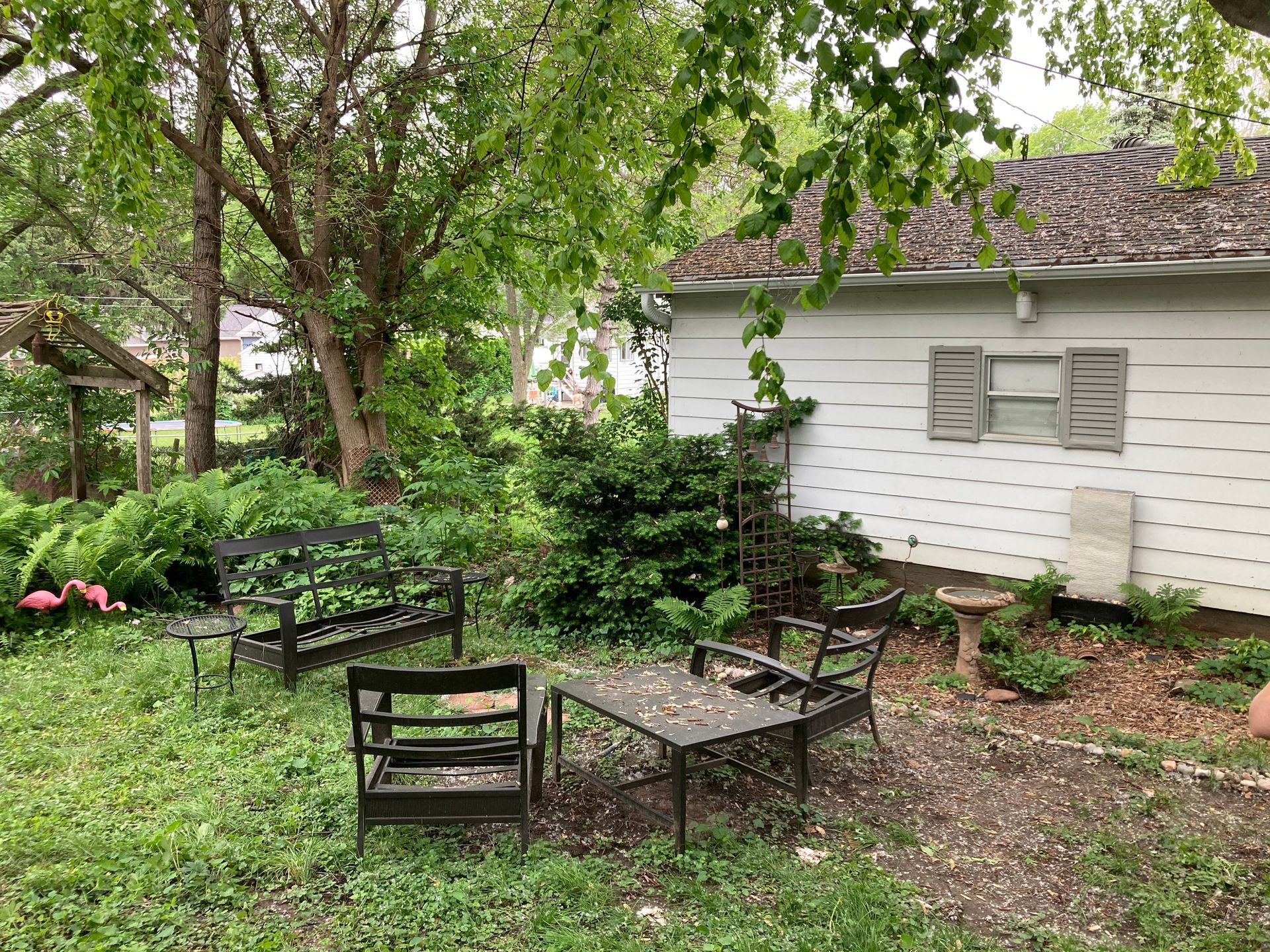 a backyard with a table and chairs in front of a house