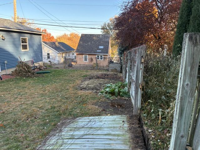 Backyard featuring a worn wooden fence and nice lawn.