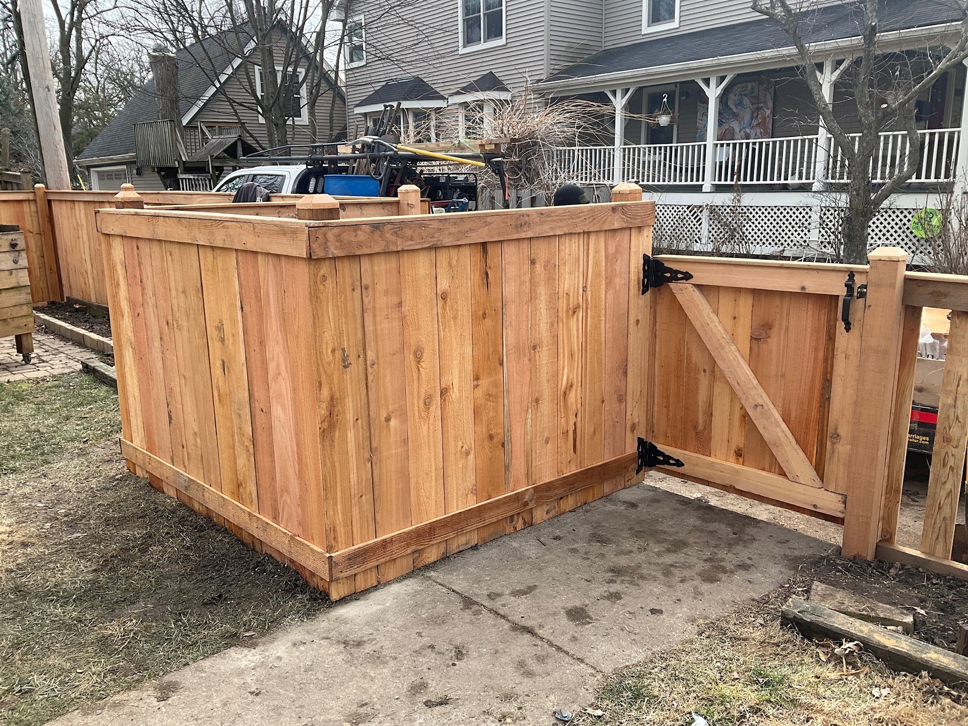 Wooden fence with gate; front yard of a house.