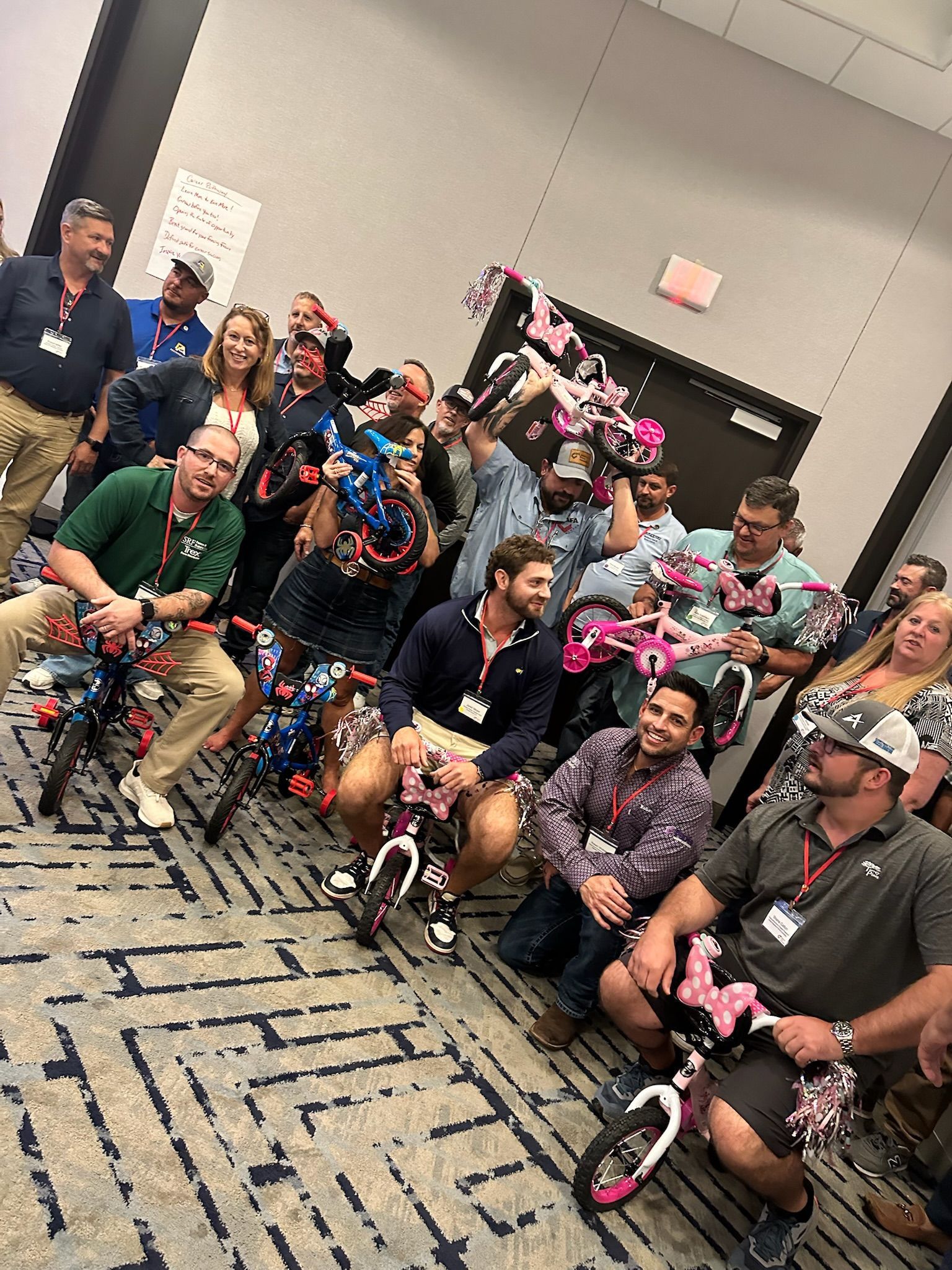 Group of people with unicycles, some decorated, posing in a room.