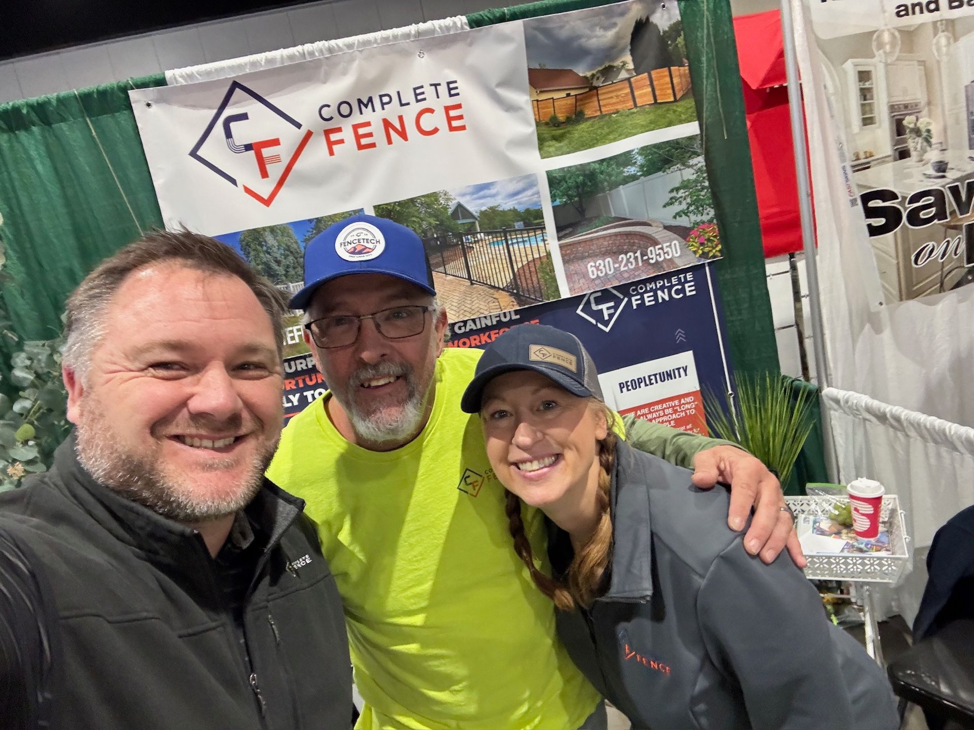 Three people smiling in front of a 