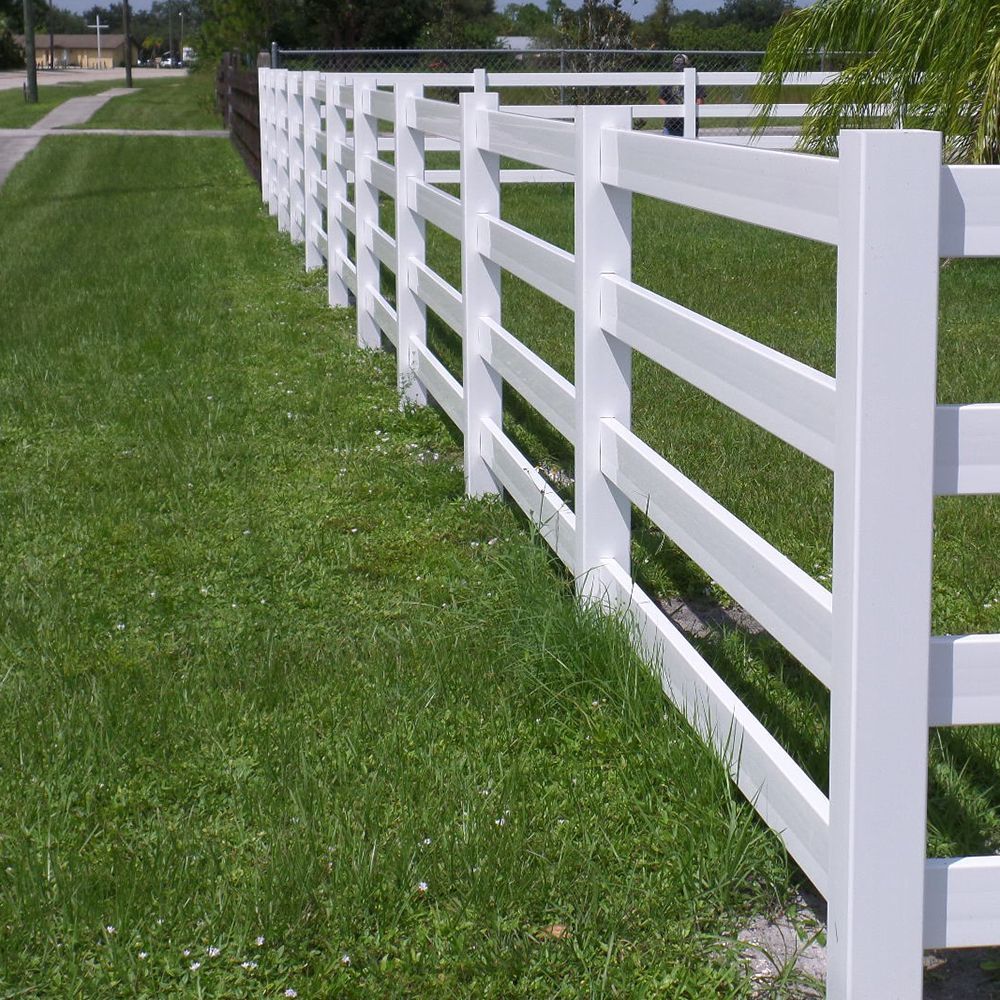 White picket fence along a green lawn beside a sidewalk.