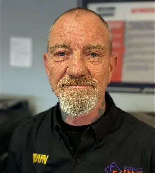 Man with shaved head and goatee in a black shirt, looking at the camera.