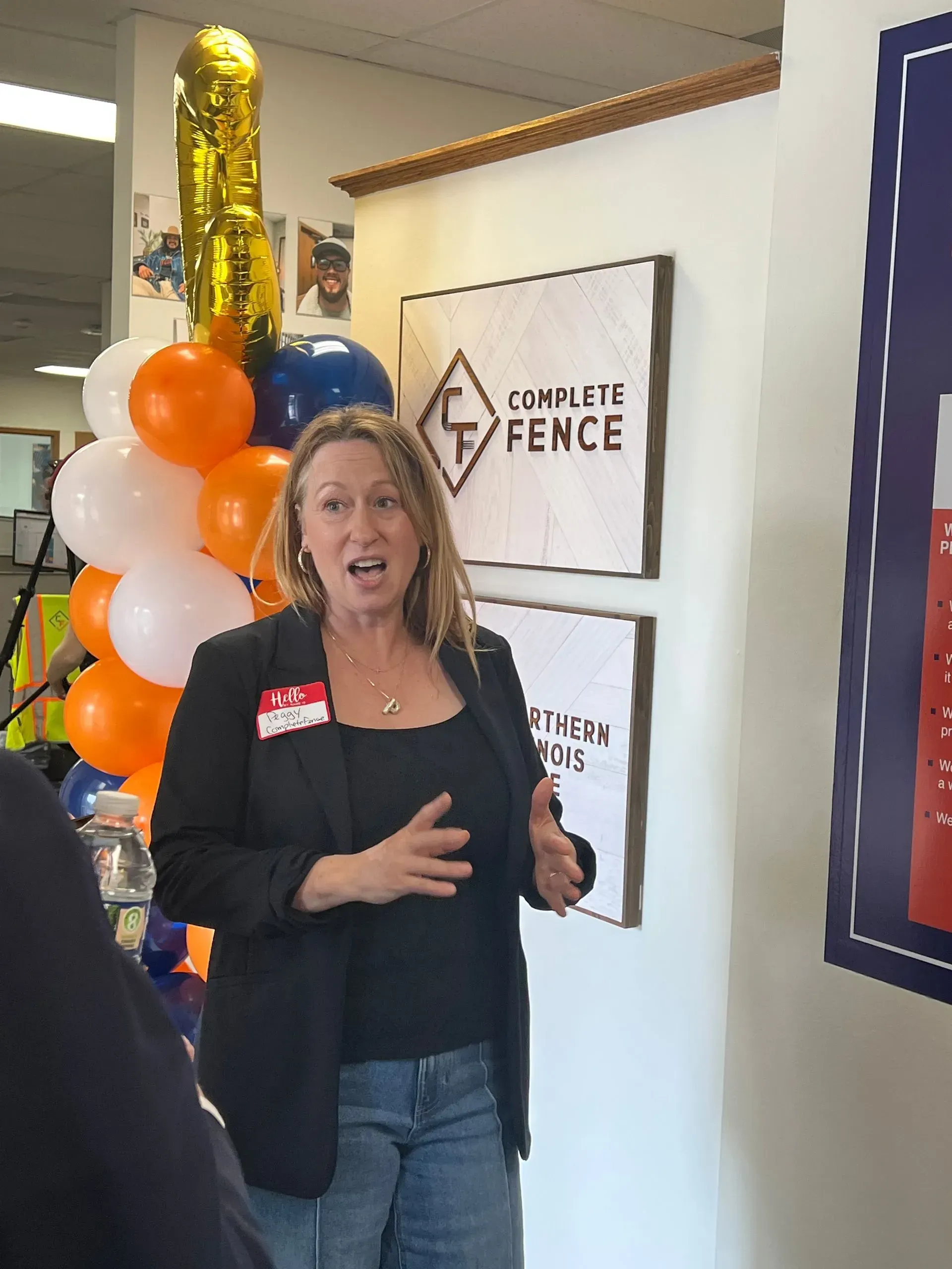 Woman speaks at event with balloons; 