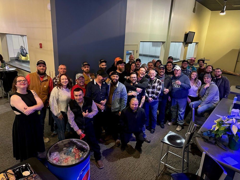 Group of people smiling, posing in a room, some wearing hats. Blue and white decor.