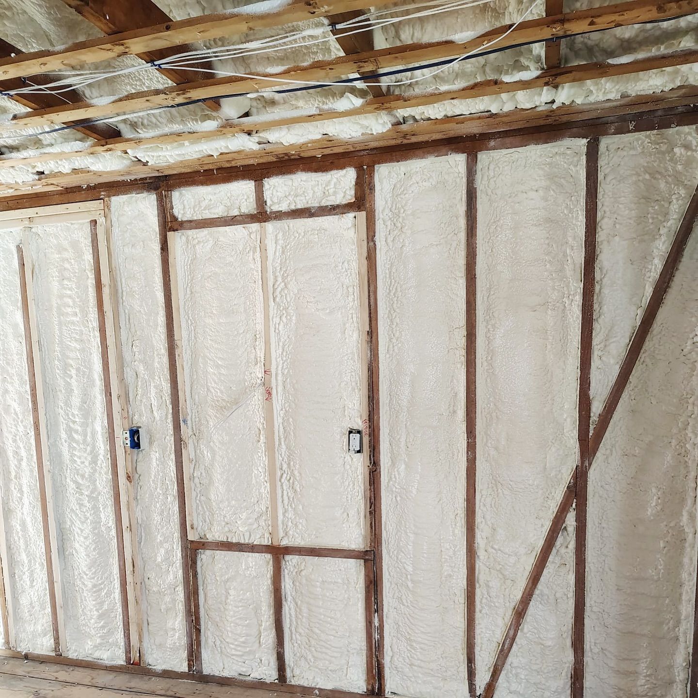 Interior framing with spray foam insulation filling the wall and ceiling cavities.