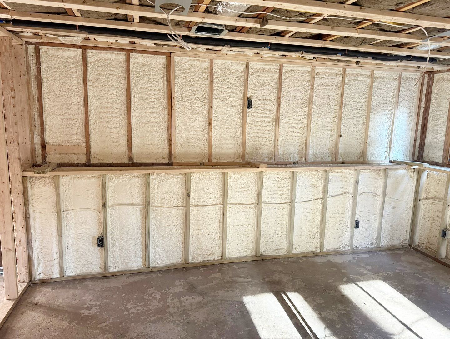 Interior of a room under construction, insulation between wooden studs.