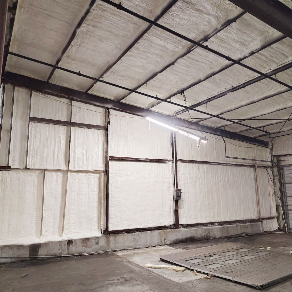 Warehouse interior with spray foam insulation on walls and ceiling.