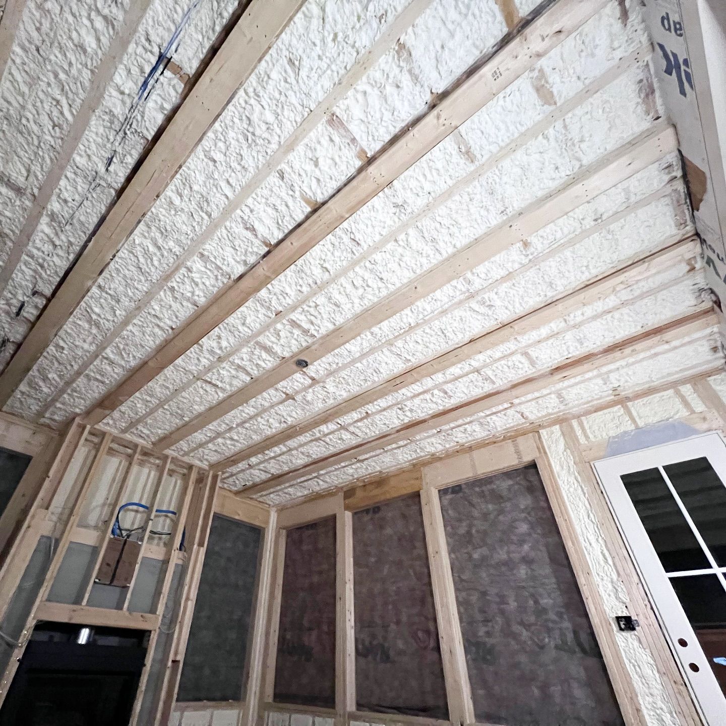 Interior of a building with spray foam insulation applied to the ceiling and walls.