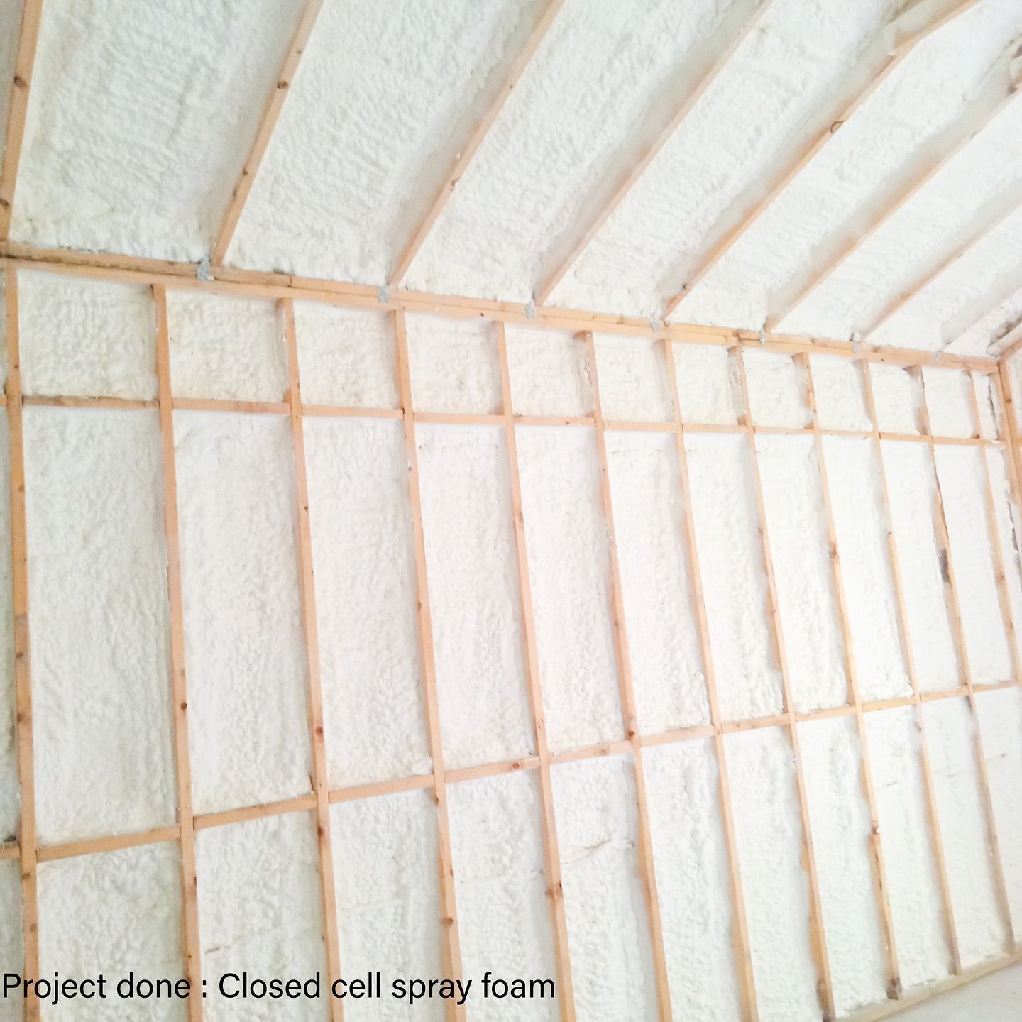 Wooden frame with spray foam insulation on walls and ceiling; project done: closed-cell spray foam.