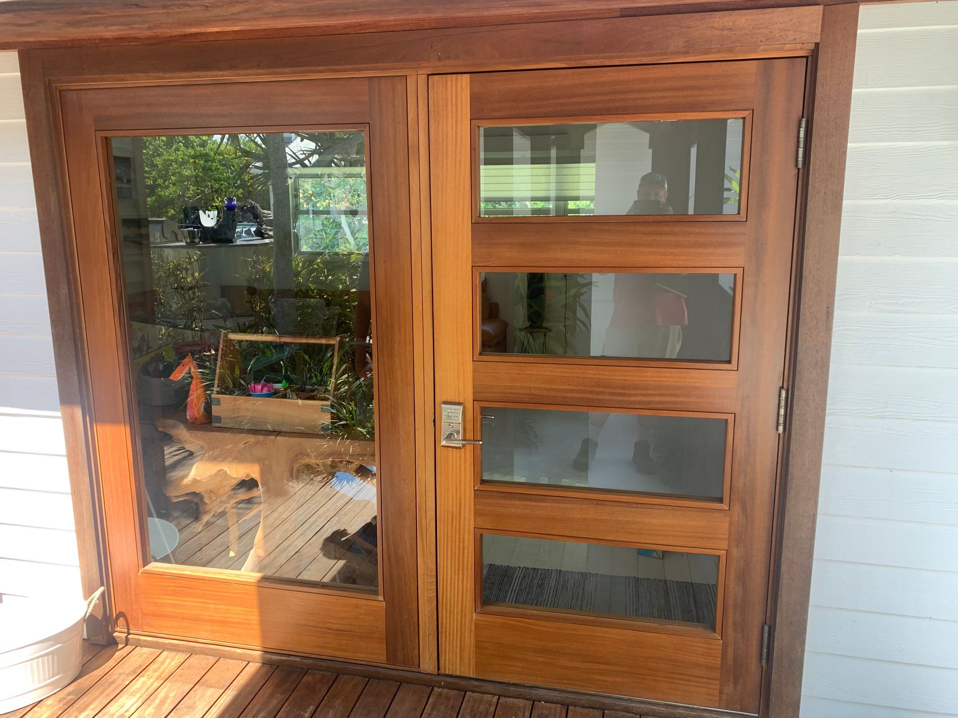 Wooden front door with glass panels and sidelights on a porch