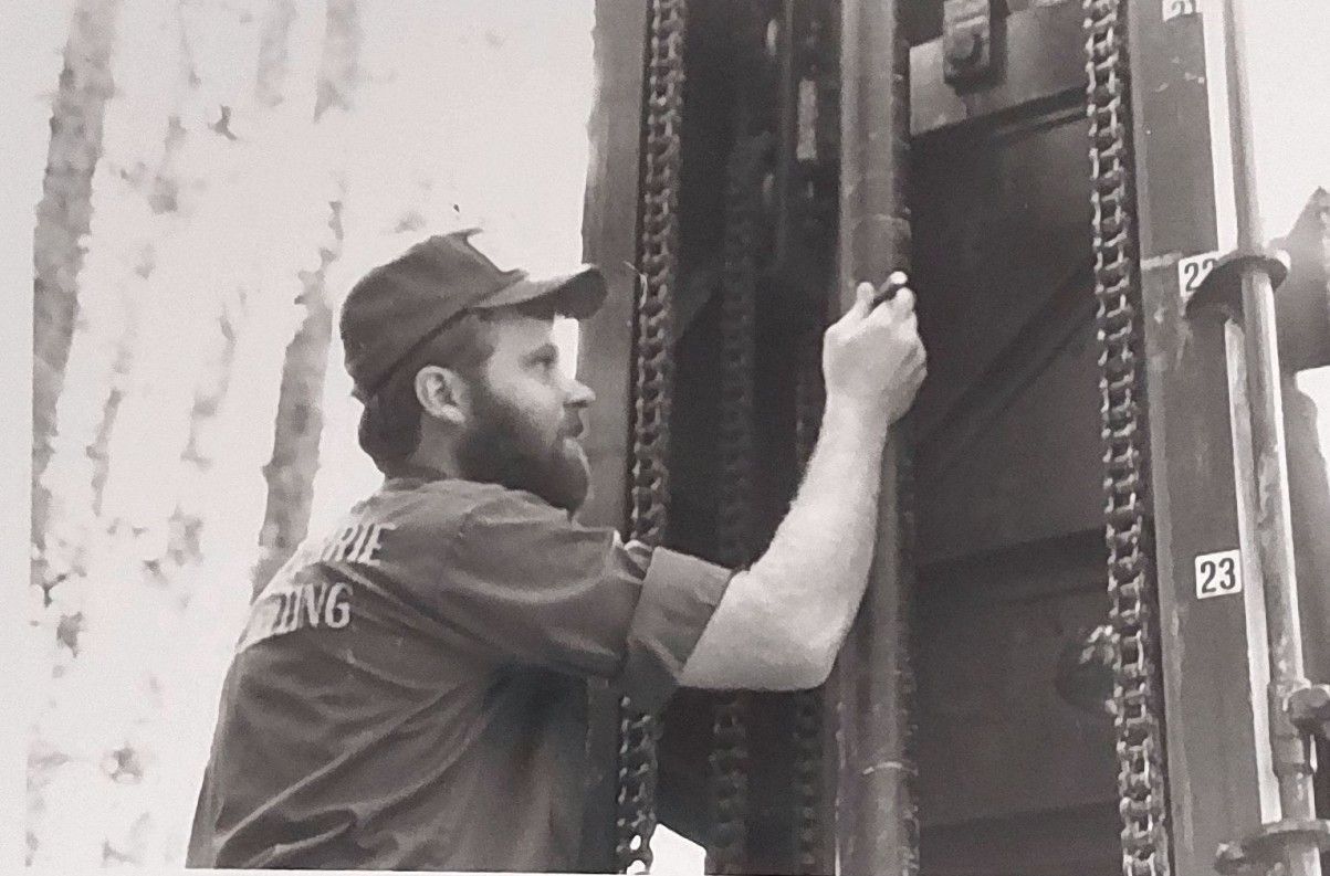 A man with a beard is working on a machine.