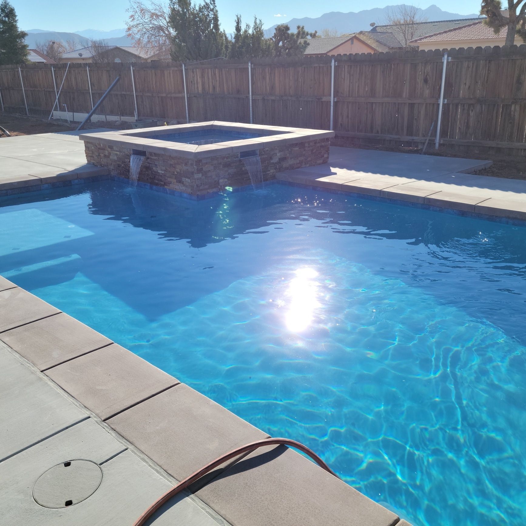 A large swimming pool surrounded by a wooden fence
