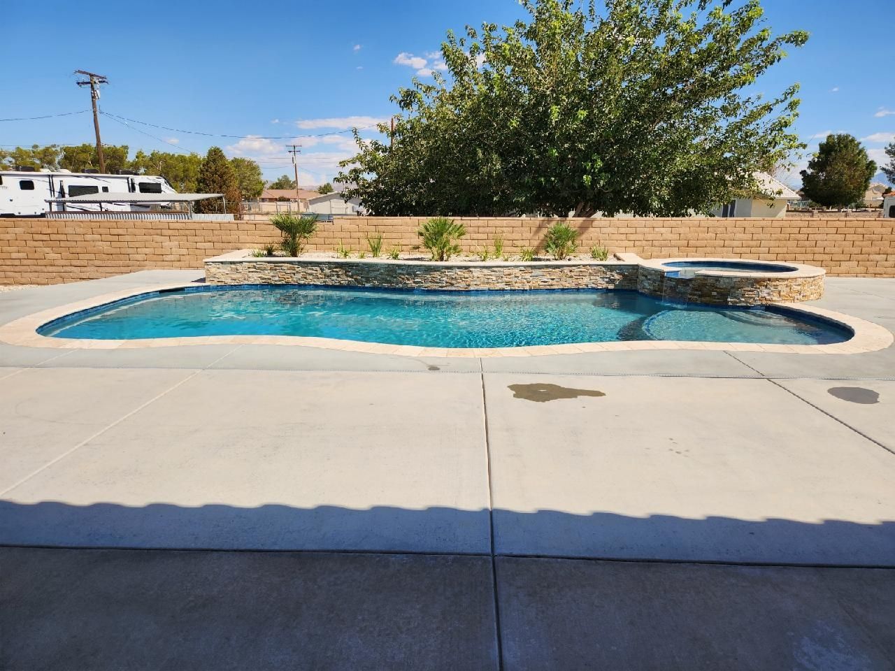A large swimming pool is sitting on top of a concrete patio.