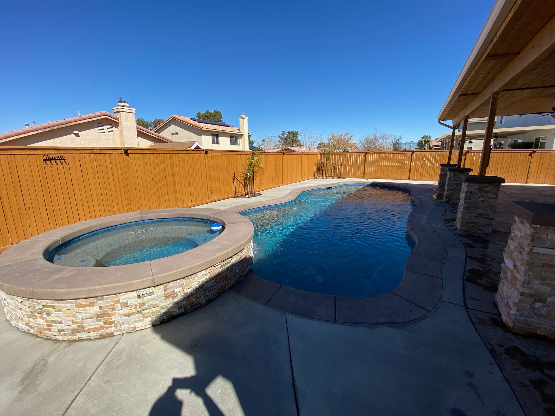 A large swimming pool with a hot tub in the middle of it.
