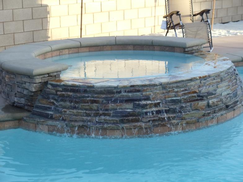 There is a hot tub in the middle of a swimming pool.