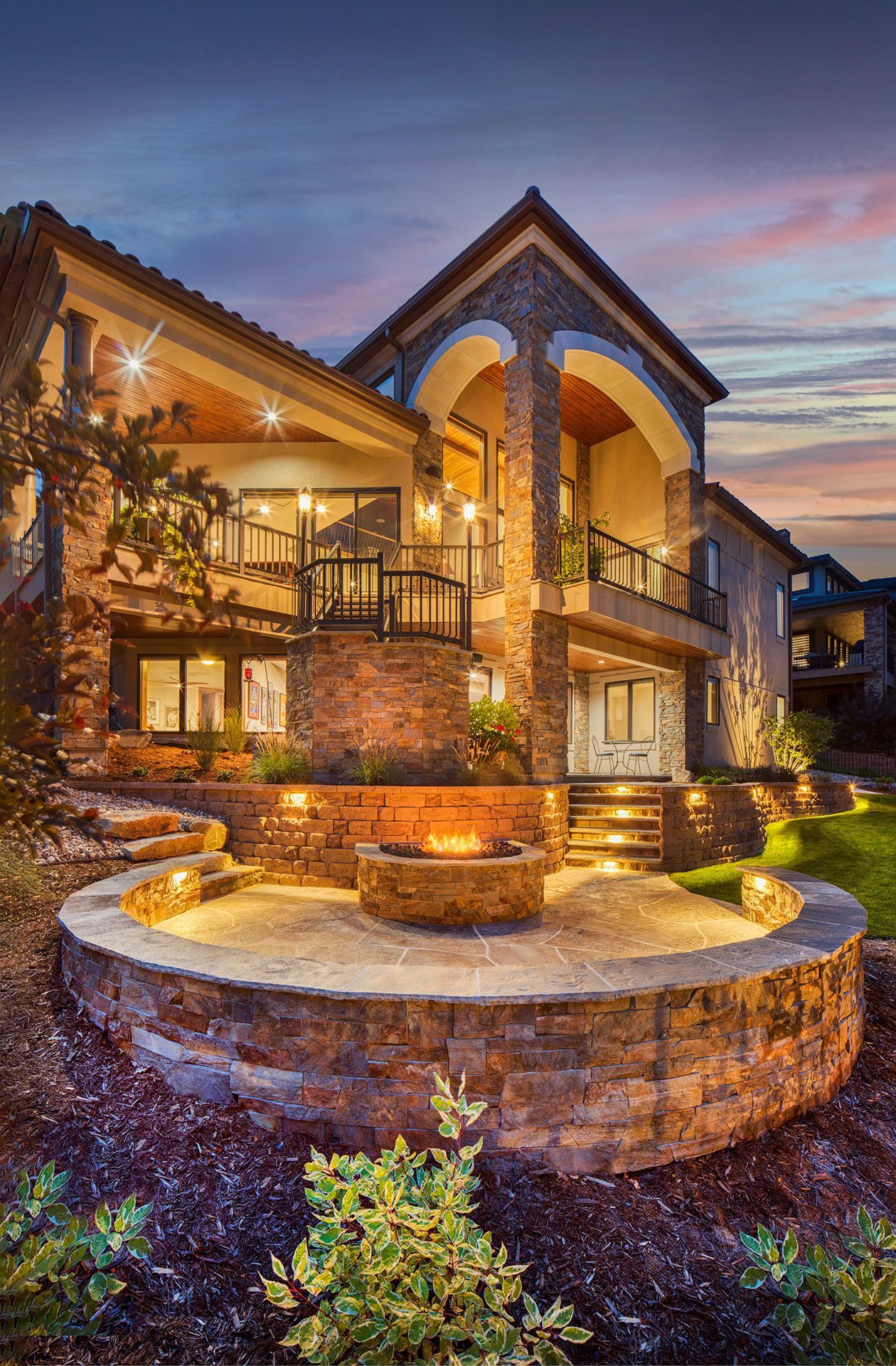 a large house with a fire pit in front of it