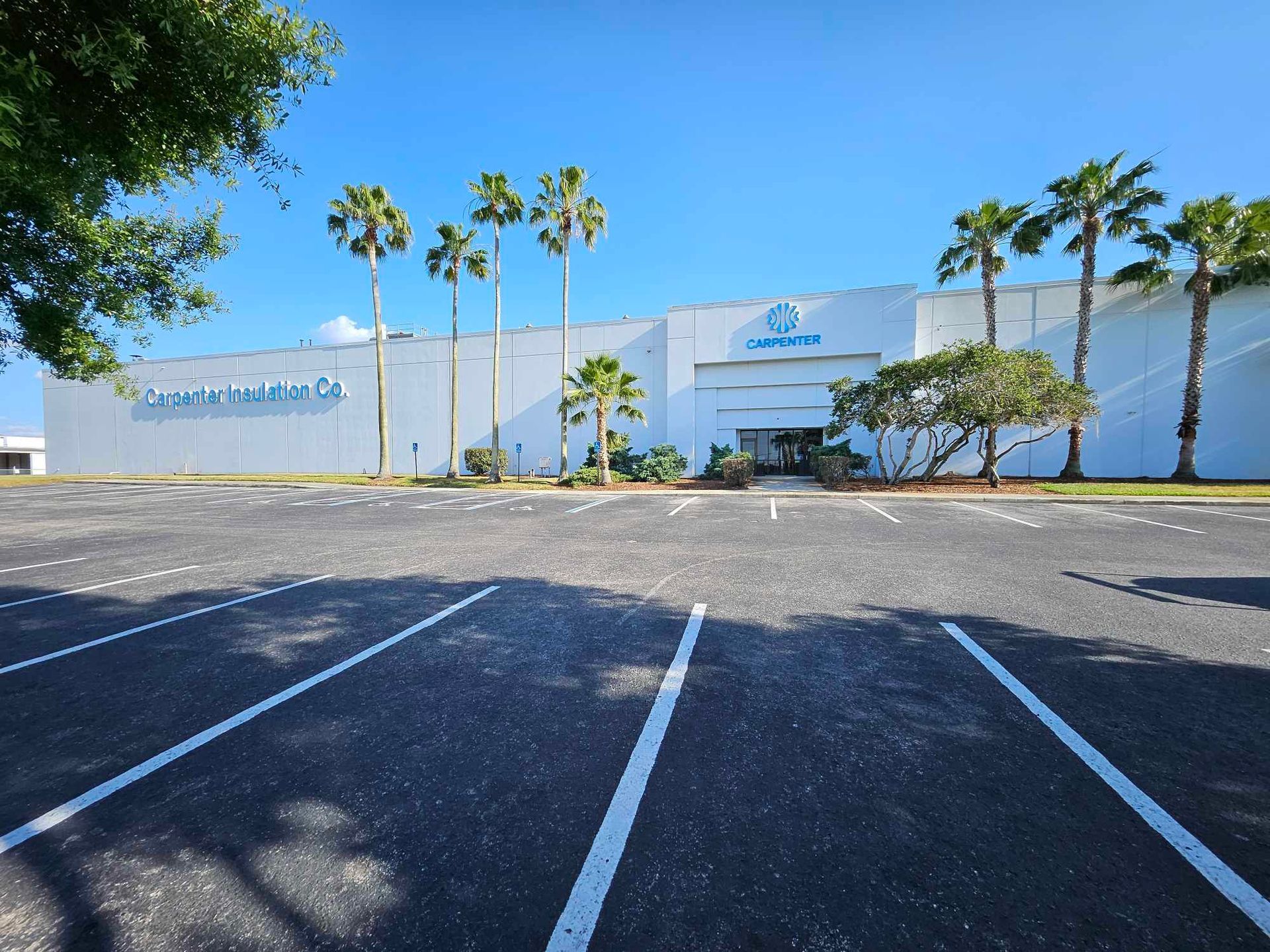 A large white building with palm trees in front of it