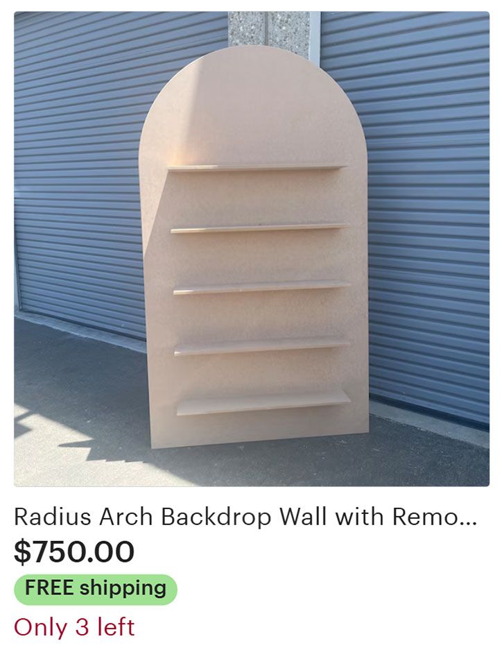 Beige arched backdrop wall with shelves.