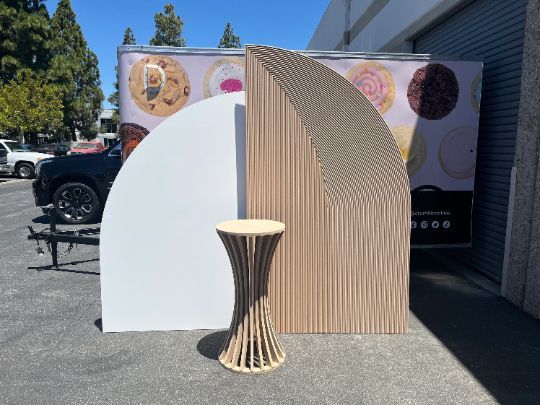A wooden table is sitting in front of a donut truck
