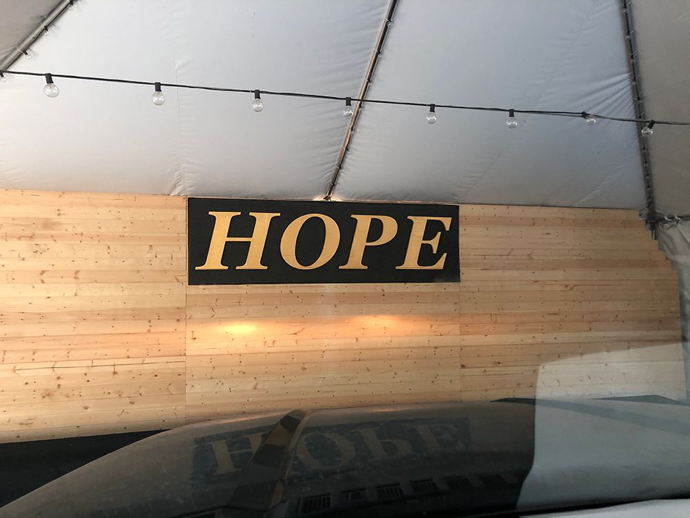 A sign on a wooden wall that says hope
