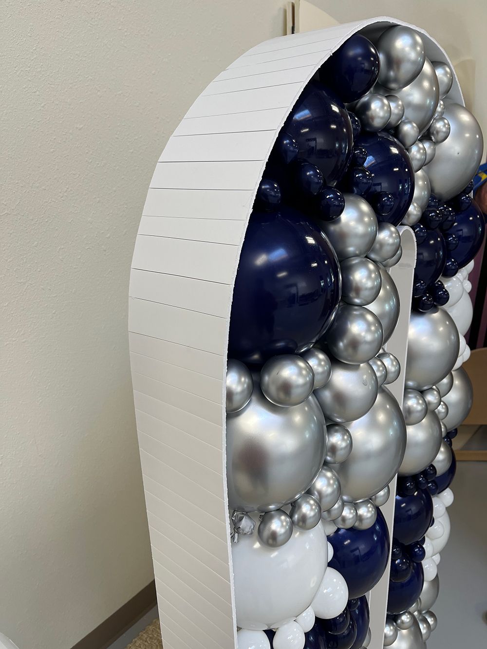 A large letter n made of blue, silver and white balloons