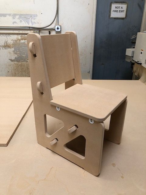 A small wooden chair is sitting on a wooden table