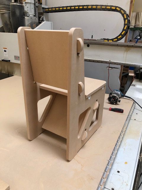 A wooden chair is sitting on top of a wooden table