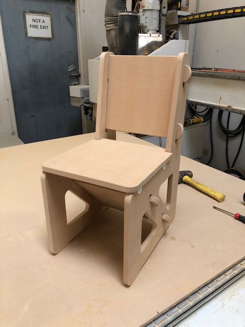 A small wooden chair is sitting on a wooden table
