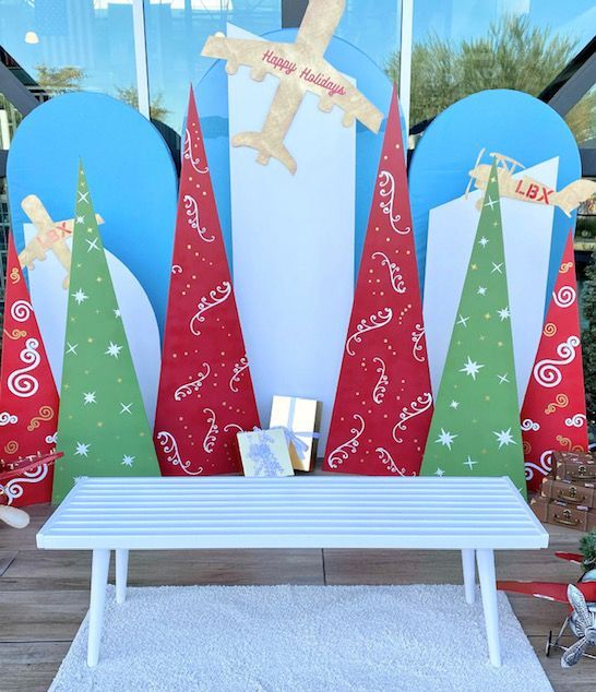 A christmas scene with trees and a plane that says happy holidays