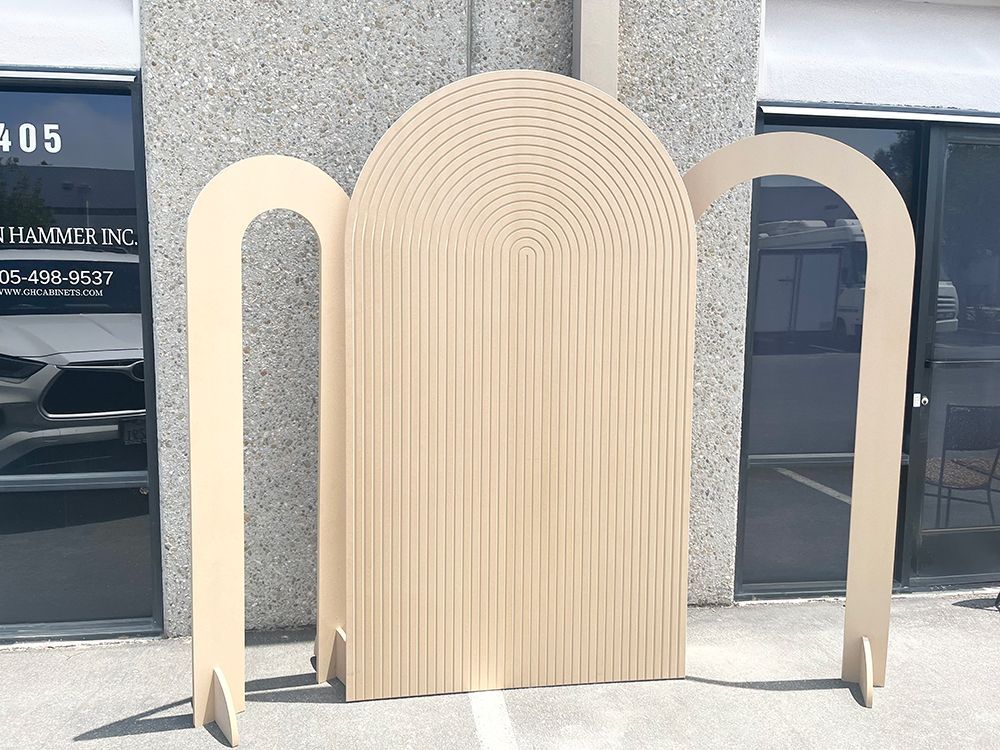 A wooden arch is sitting in front of a building