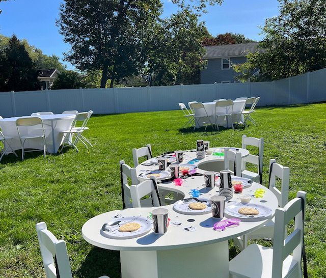 A lawn with tables and chairs set up for a party