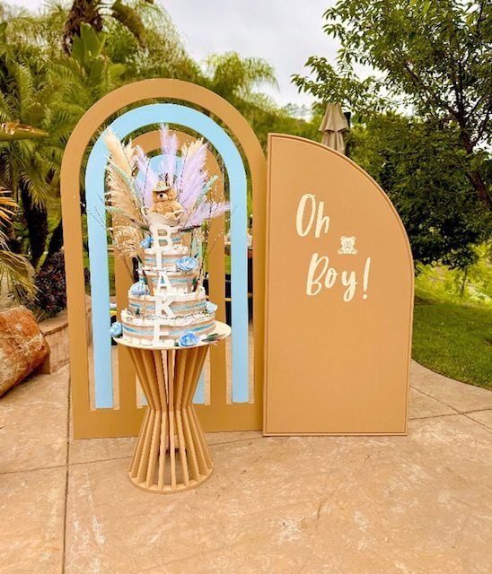 A cake on a table in front of a sign that says oh boy