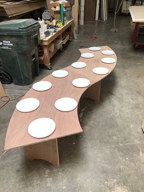 A wooden table with white plates on it in a workshop