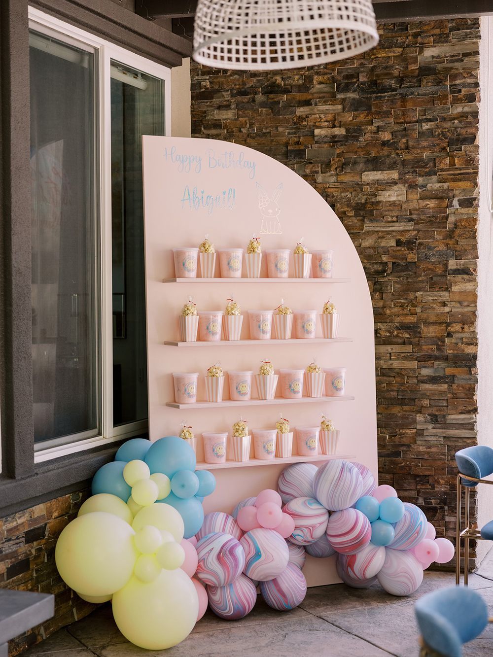A wall decorated with balloons and cups for a baby shower