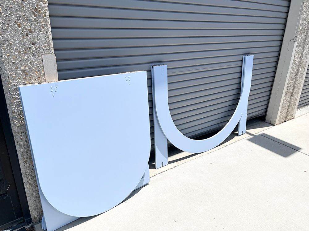 A piece of metal is sitting on the sidewalk in front of a garage door