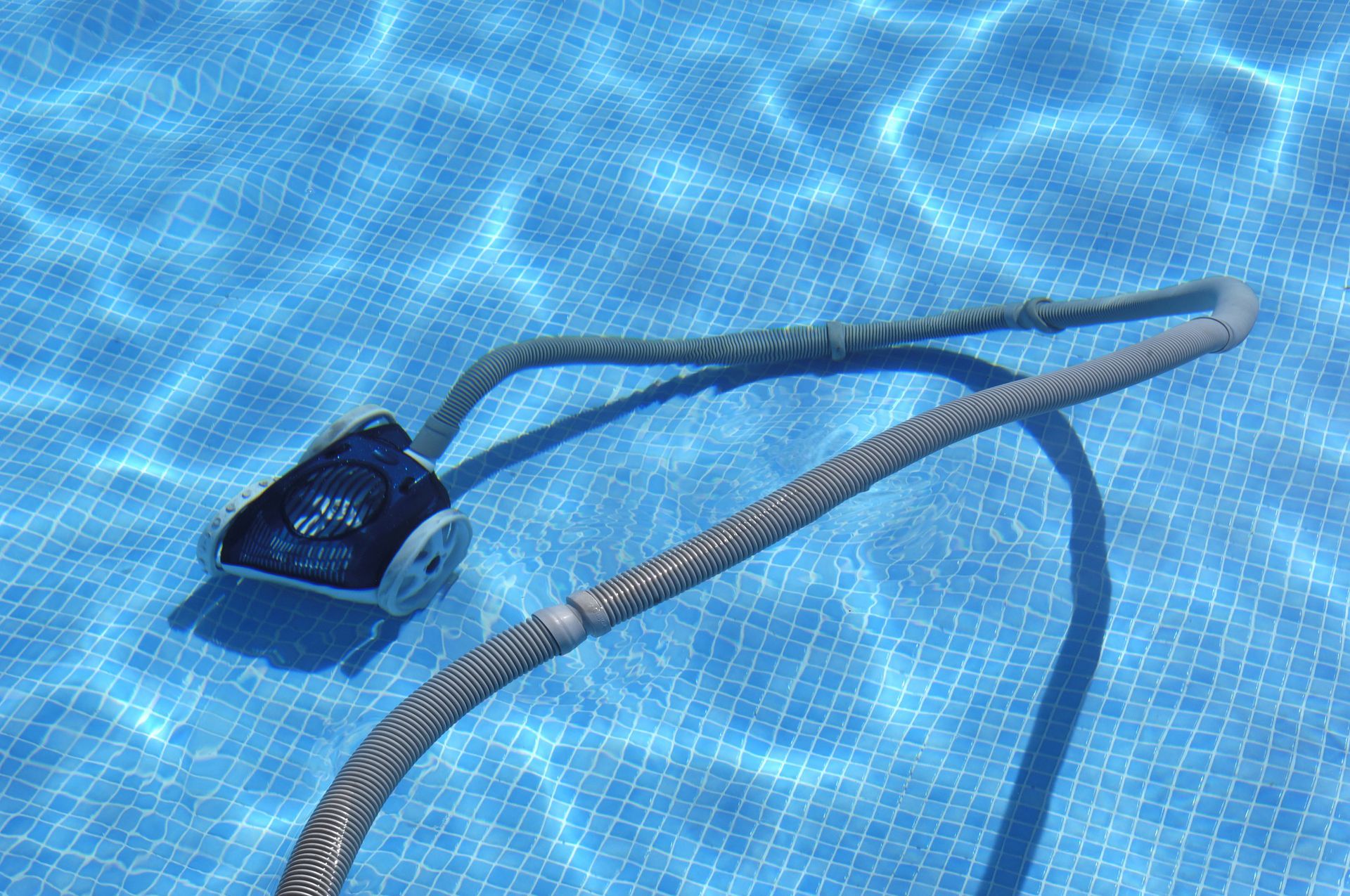 Pool cleaner in a blue tiled pool.