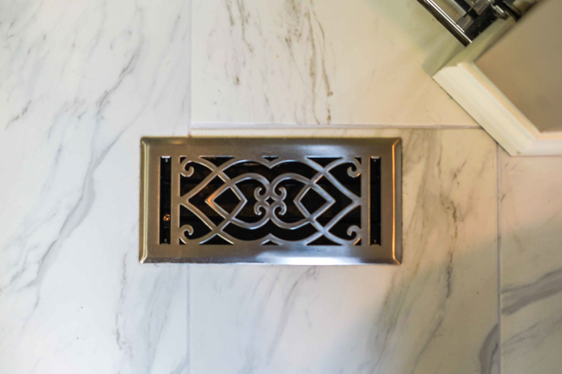 A marble floor with a metal grille on it