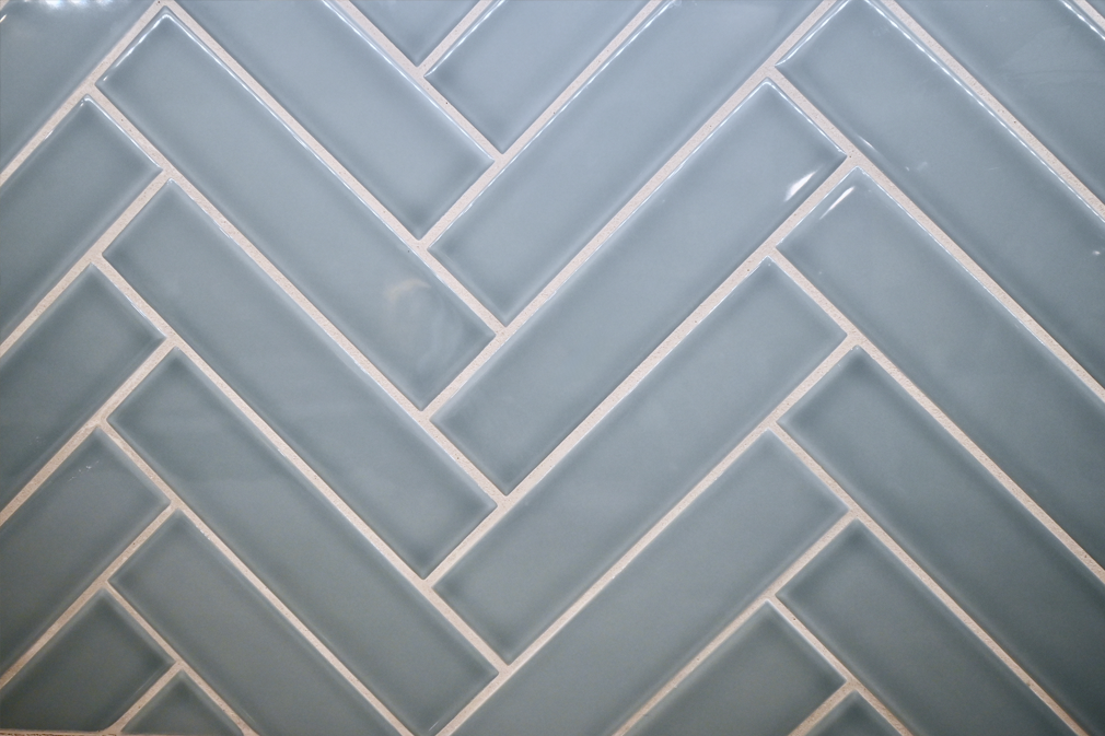 Light blue rectangular tiles in a herringbone pattern with white grout.