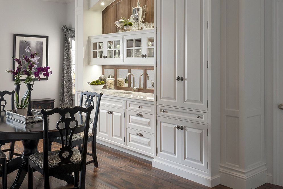 A dining room with a table and chairs and white cabinets