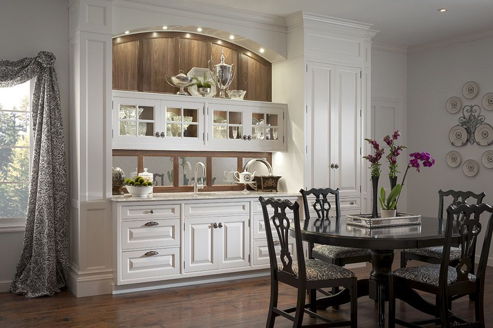 A dining room with a table and chairs and a sink.