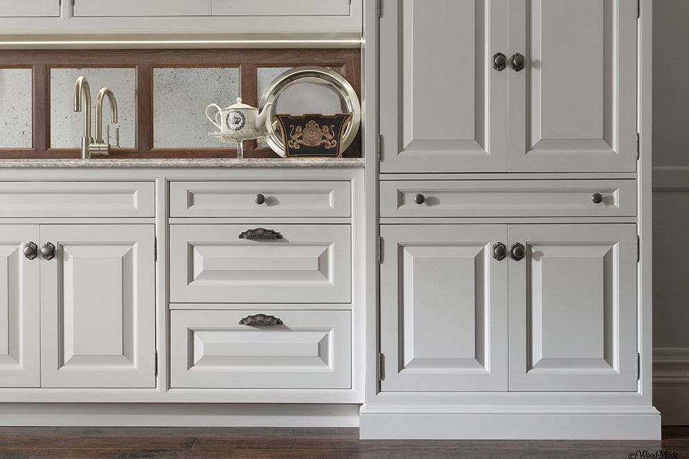 A kitchen with white cabinets and drawers and a sink.