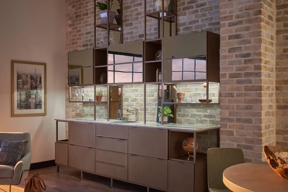 A living room with a brick wall , a table , chairs , and a couch.