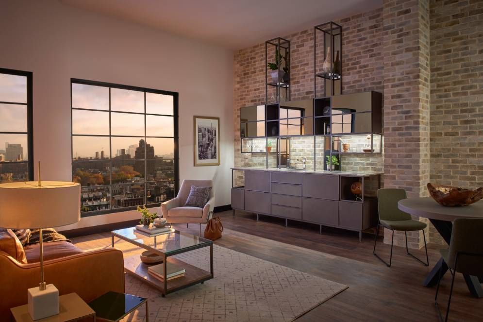 A living room with a couch , table , chairs , and a large window.